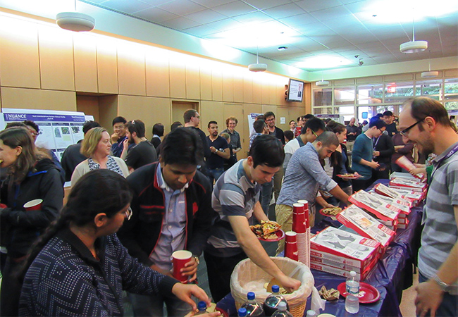 Students, staff, and faculty enjoy pizza at the reception